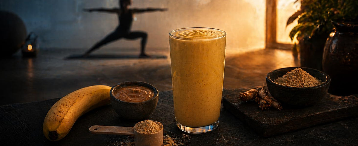 Vaso de batido de plátano con ashwagandha, plátano entero y bol de polvo sobre tabla de madera