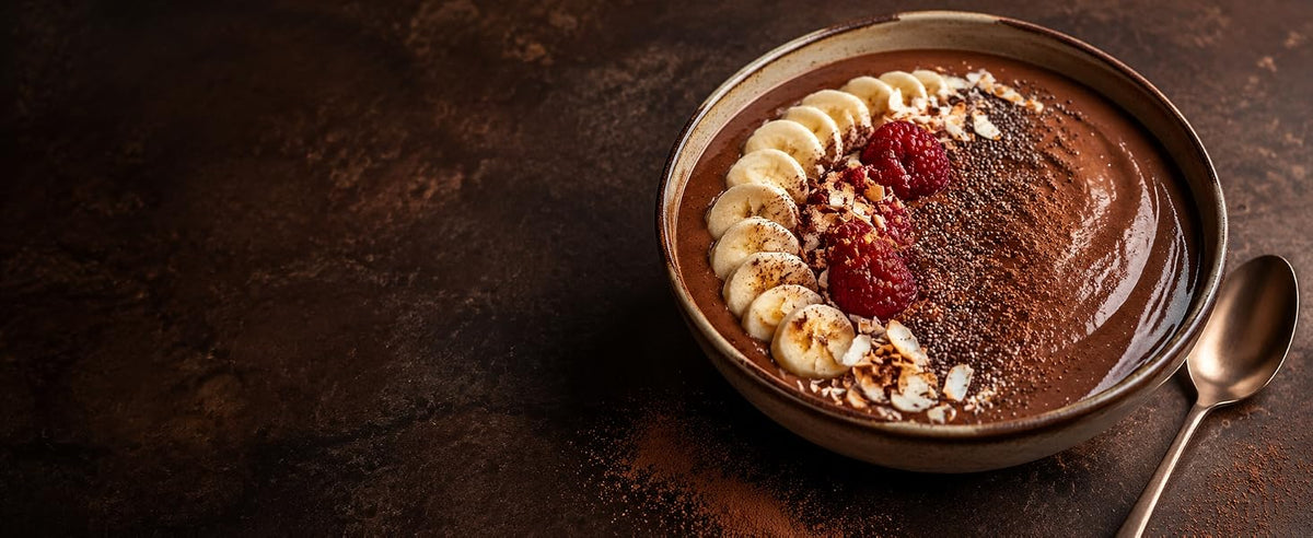 Bowl de smoothie de cacao con plátano, frambuesas y semillas