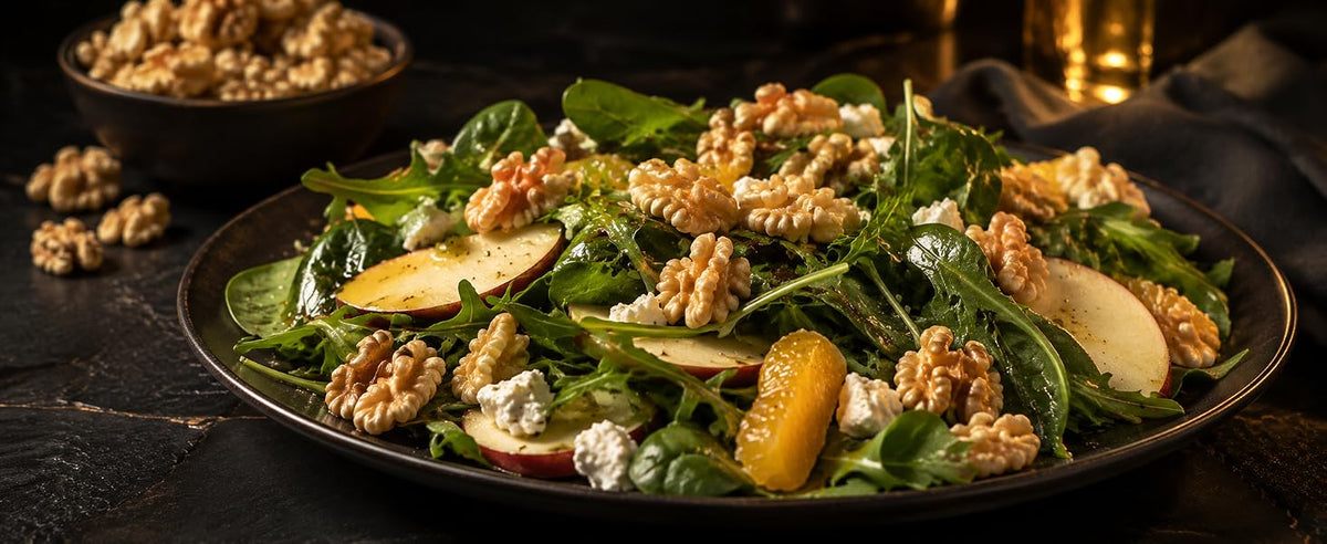 Ensalada de rúcula y espinacas con nueces, queso azul, manzana y naranja en plato oscuro